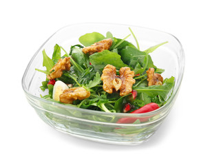 Delicious fresh salad with walnuts in glass bowl on white background