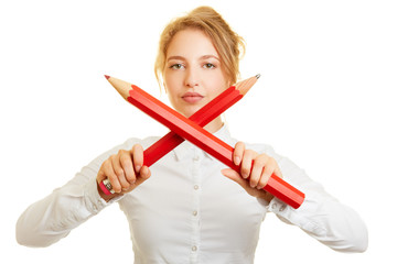 Frau hält zwei gekreuzte große Stifte zur Abwehr