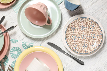 Different tableware and cutlery on wooden table