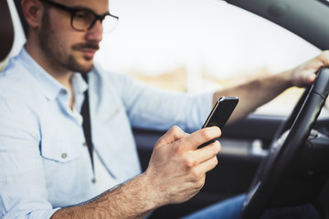 Obraz na płótnie Canvas Man driver using smart phone in car modern