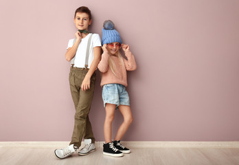 Cute boy and girl in fashionable clothes near color wall © Pixel-Shot