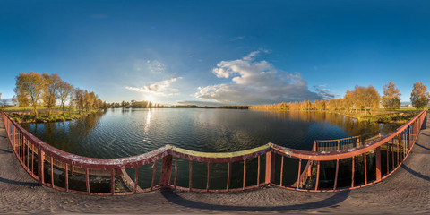 full seamless spherical panorama 360 degrees angle view golden autumn near the dam of wide lake in...
