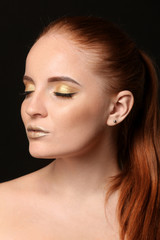 Fototapeta premium beauty and self-care, portrait of a woman with metallic gold makeup