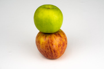 A red apple and a green apple in closeup on a white background