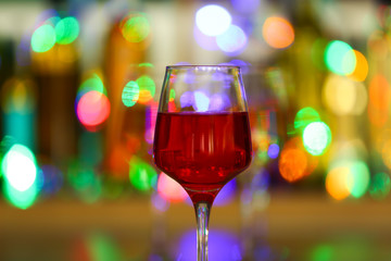 Glass of tasty wine against defocused lights
