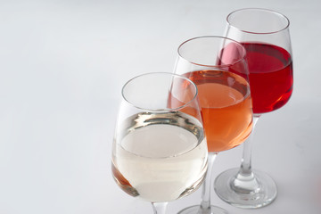 Glasses of tasty wine on white background