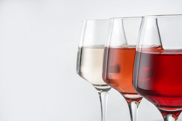Glasses of tasty wine on white background, closeup