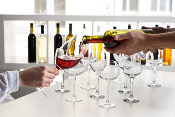 Barman pouring tasty wine in glass at party