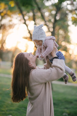Young mother and her little baby daughter having fun in a park