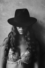 Fashion portrait of a woman with curly hair and black and white hat