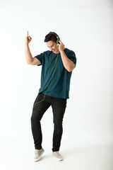 Emotional young man listening to music on white background