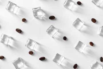 Ice cubes and coffee beans on white background