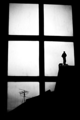 A workman's silhouette on the roof. Man at work in black and white.