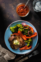Grilled Beef steak with garlic butter and vegetables. Meat with grilled bell pepper, broccoli and onions.