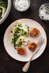 Chicken meat balls with zucchini salad and green peas, with garlic-yogurt sauce.