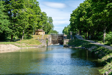 Fototapeta na wymiar Sea lock at Gota canal in Sweden, with green trees along the river bank