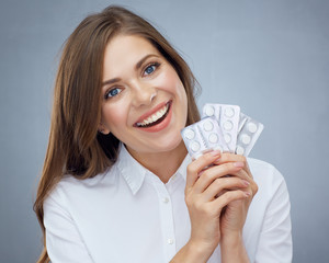 Happy woman holding pils in blister pack