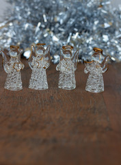 Christmas decoration. Crystal angels ornaments. Silver tinsel. Wooden Background. Vertical . Copy Space