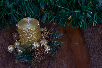 Christmas decoration. Close up golden glitter candle. Wooden Background.  Copy Space