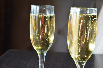 two glasses of champagne on a table in a restaurant. wine or champagne pouring in wine glass. concept for drink and beverage.Blur background