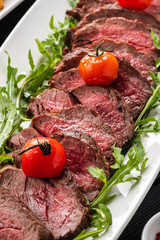 Chateaubriand steak. Served with fried potatoes, champignons, cherry tomatoes and Spanish sauce