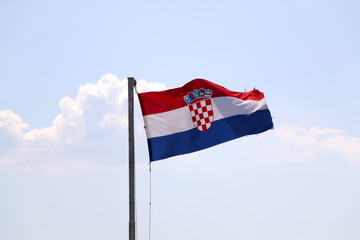 Flag of Croatia, blowing in the wind. Sky in the background, selective focus.
