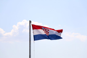 Flag of Croatia, blowing in the wind. Sky in the background, selective focus.
