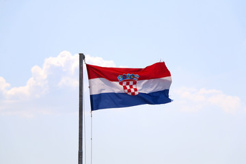 Flag of Croatia, blowing in the wind. Sky in the background, selective focus.
