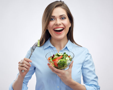 Happy woman with big toothy smile holding salad bowl.