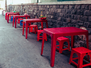 Red plastic table and chair combo on the street of Vietnam | where people eat street food in Saigon city, Vietnam 