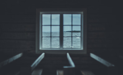 View through window in wooden cabin onto the ocean