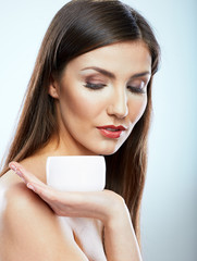 Woman holding white cream jar.