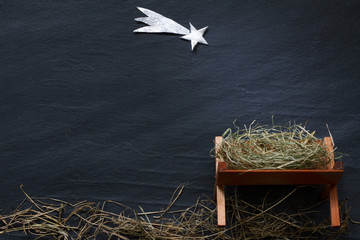 Manger and star of Bethlehem abstracy christmas background nativity scene on black marble
