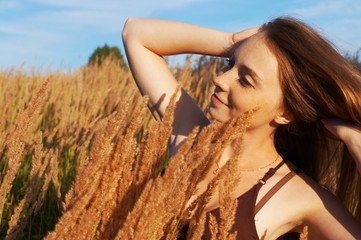 girl in a field with high golden ears   