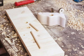 Wooden details for toy cars on the table in the workshop.