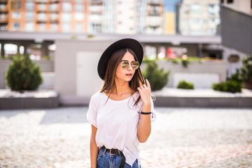 Pretty hipster girl in sunglasses and hat lifestyle outdoor portrait