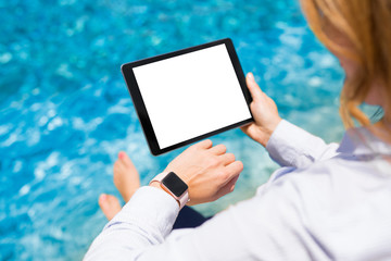 Woman using modern technology gadgets on vacation by the pool