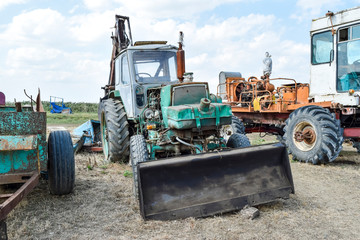 Russia, Temryuk - 15 July 2015: Tractor. Bulldozer and grader. Tractor with a bucket for digging soil. The picture was taken at a parking lot of tractors in a rural garage on the outskirts of Temryuk.