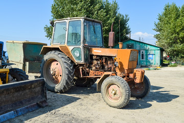 Obraz premium Russia, Temryuk - 15 July 2015: Tractor. Agricultural machinery tractor. Parking of tractor agricultural machinery. The picture was taken at a parking lot of tractors in a rural garage on the