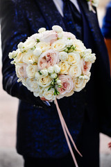 Bouquet da sposa realizzato con tante roselline colorate tenuto dallo sposo