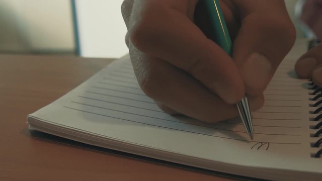 An inspiring message for empowering people to take their own fate in their hands and write their own story. A hand picking up a pen and writing inspiring words. UHD 3840 x 2160 pixels.