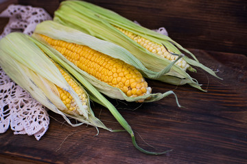 Fresh yellow corn on a wooden board. Row of delicious boiled fresh corn cobs for a healthy snack.