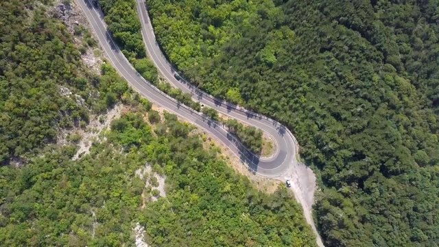 Aerial view of the movement of vehicles on a serpentine mountain road. Croatia. Top view