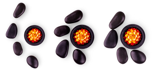 Set of black stones and a candle on white background