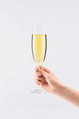 cropped shot of woman holding glass of champagne in hand isolated on white