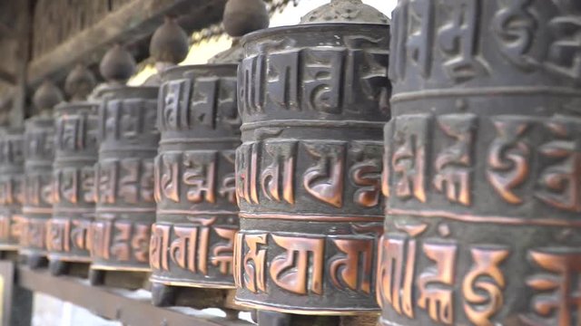 Prayer Drums In Swayambhunath or monkey temle. Kathmandu, Nepal. Swayambhunath, or Swayambu or Swoyambhu, is an ancient religious architecture atop a hill in the Kathmandu Valley.