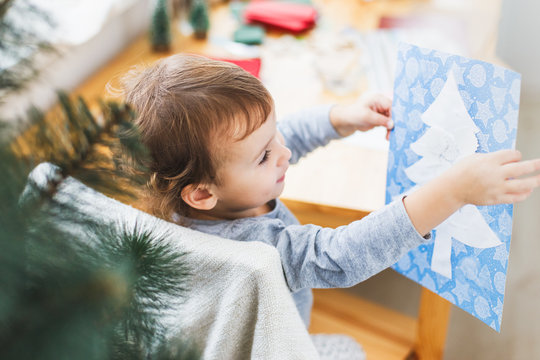 Cute little girl preparing christmas picture with christmas tree.