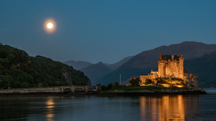Eilean Donan castle at moonrise, with it's own reflection in the bay, Scotland, UK