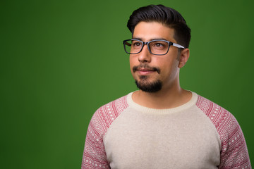 Fototapeta premium Young bearded Iranian man against green background