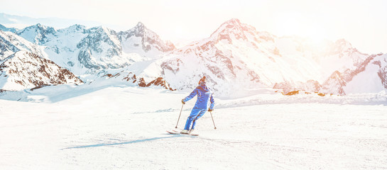 Young athlete skiing in alps mountains on sunny day